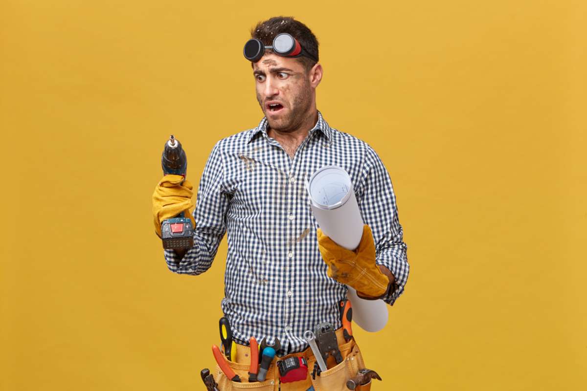 DIY repairman with a tool belt and drill trying to fix a problem in an Indianapolis investment property