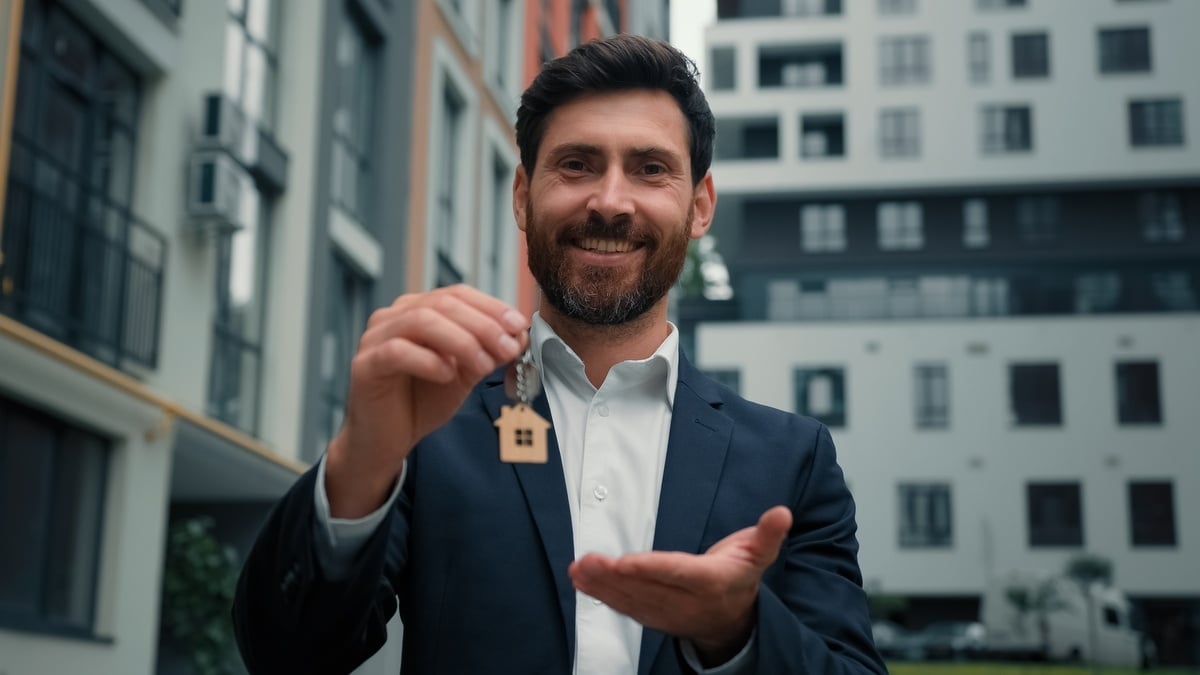 Professional man holding a key with a house keychain