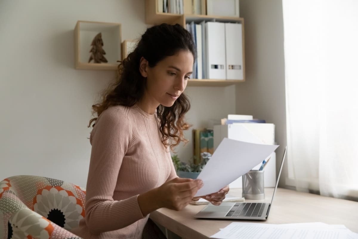 A woman reading a letter sitting at her desk